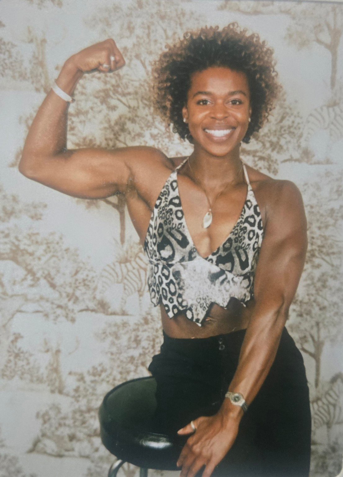 Linette during her competition years, smiling and flexing